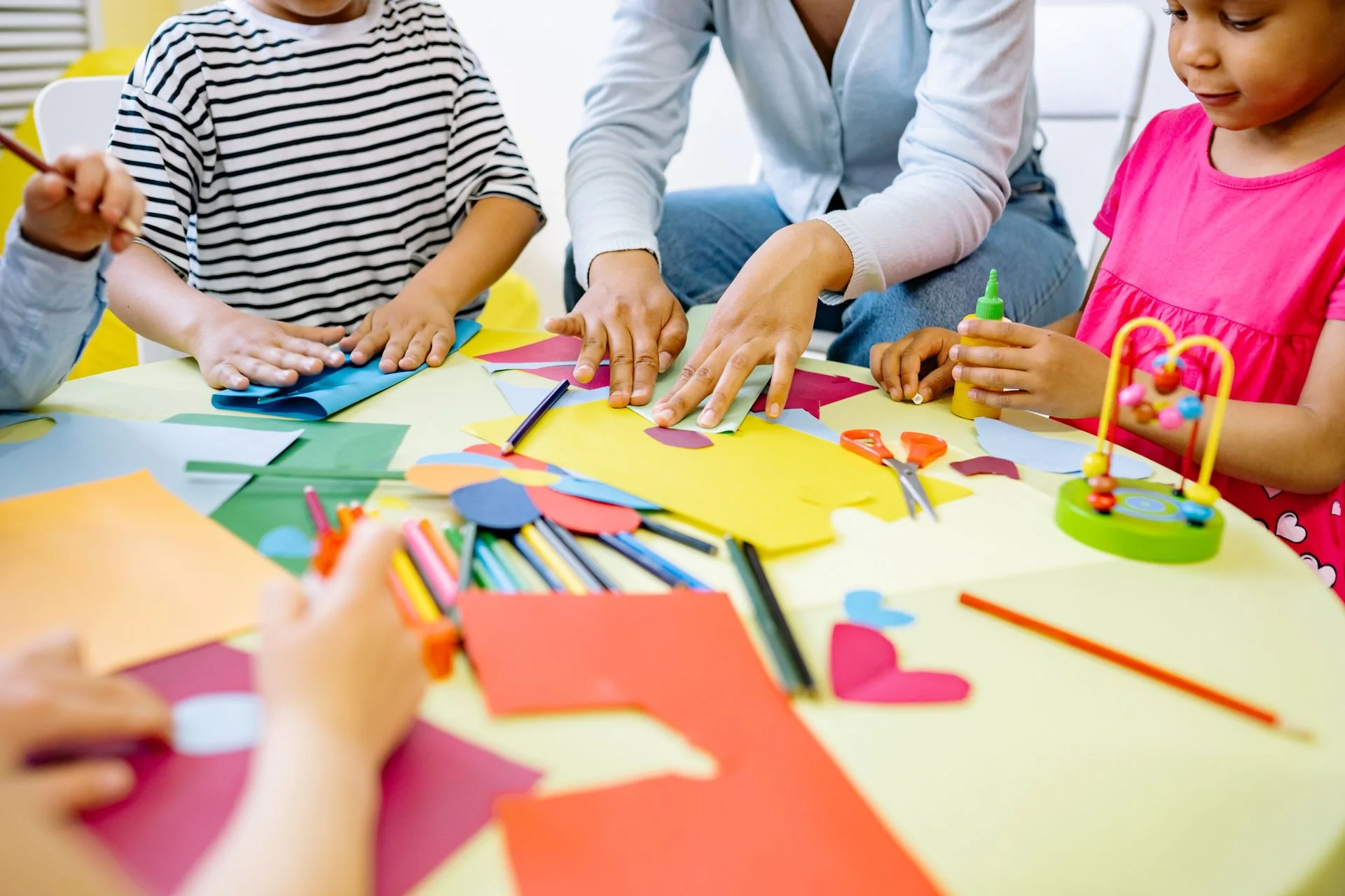 Children creating colourful paper crafts together